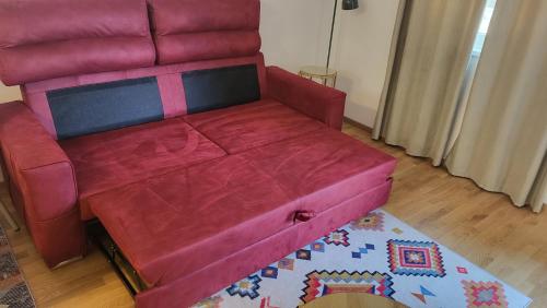a red couch sitting in a living room at BrandNew Apartment in Podgorica