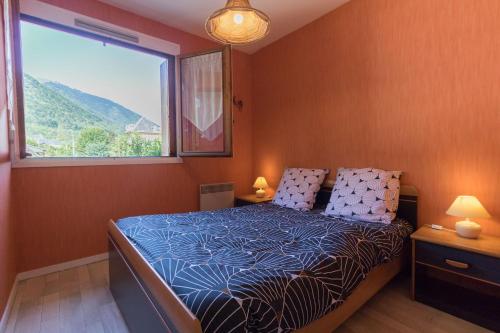 a bedroom with a bed with a large window at Vacances cures luchon in Luchon