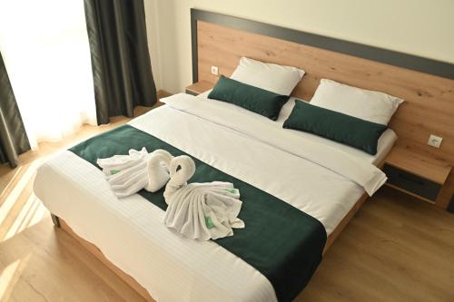 a bedroom with two swans towels on a bed at Mms lux apartmani 7 i 8 Petrovec in Skopje