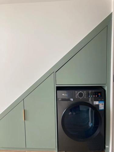 a washing machine in a room with two cabinets at Chengdu Homestay Na's House in Chengdu