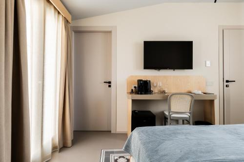 a hotel room with a bed and a desk with a television at Domus Terravecchia in Agrigento