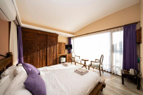 a bedroom with a bed and a large window at Lissiya Hotel in Faralya