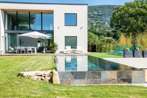une maison avec une piscine dans la cour dans l'établissement Superbe villa contemporaine, à Peymeinade