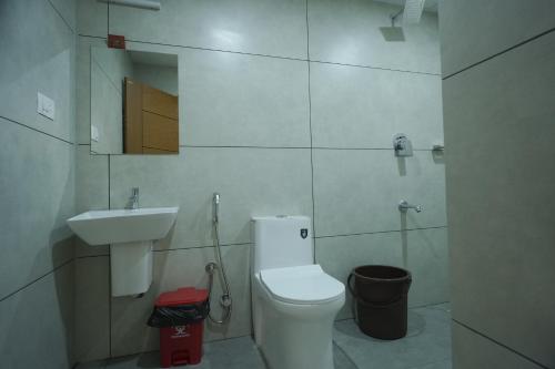 a small bathroom with a toilet and a sink at AR Suites Kothamangalam in Kotamangalam
