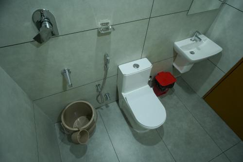a small bathroom with a toilet and a sink at AR Suites Kothamangalam in Kotamangalam