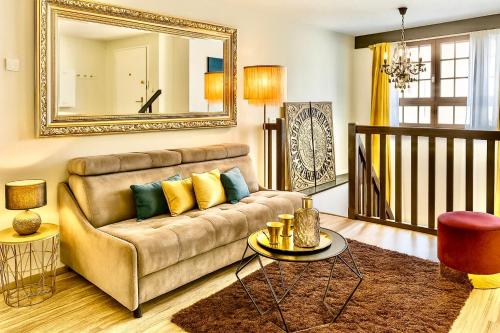 a living room with a couch and a mirror at Apartment Duplex with Sauna City- Center Cathedrale in Strasbourg