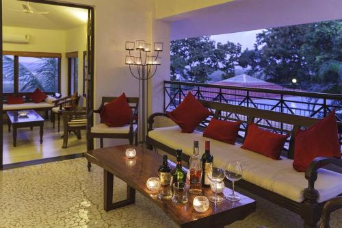 a room with a couch and a table with wine glasses at 5 Tropical Woods 4 BR VillaGoa Pool Cook in Bardez