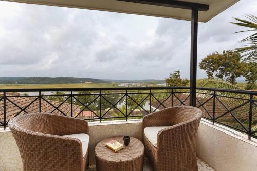 two chairs and a table on a balcony with a view at 5 Tropical Woods 4 BR VillaGoa Pool Cook in Bardez