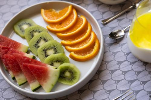 a plate of fruit with oranges and kiwis and orange slices at Domus Terravecchia in Agrigento