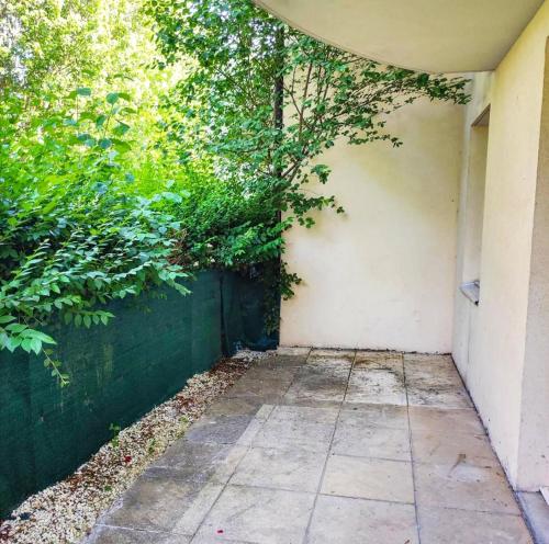 un trottoir avec une clôture verte et des arbres dans l'établissement Charmant T3 56m2 Vetraz-Monthoux, à Vétraz-Monthoux