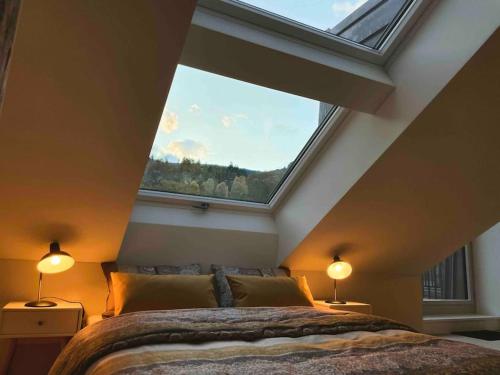 a bedroom with a large window above a bed at Stilvolles Loft mit Naturpool in Mels