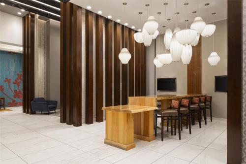 a lobby with a table and chairs and chandeliers at Hilton Garden Inn New York/Midtown Park Avenue in New York