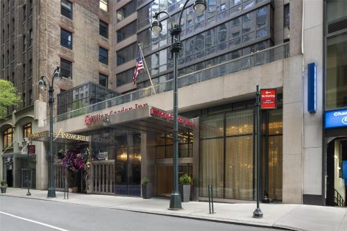 a building on a city street with an american flag at Hilton Garden Inn New York/Midtown Park Avenue in New York