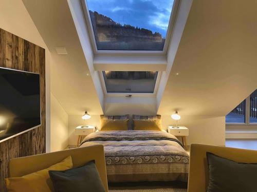 a bedroom with a bed and a large window at Stilvolles Loft mit Naturpool in Mels