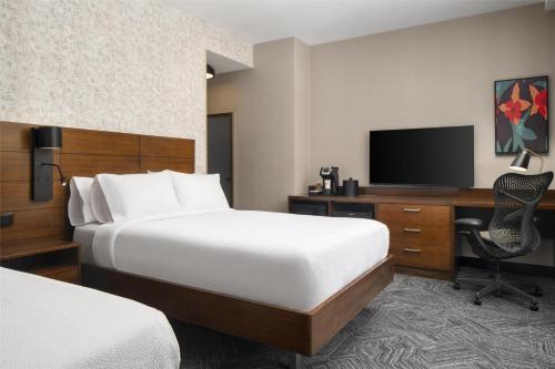 a hotel room with a bed and a desk and a television at Hilton Garden Inn New York/Midtown Park Avenue in New York
