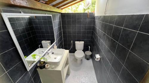 a bathroom with a sink and a toilet and a mirror at Tahlia's Villa in Sorongjukung