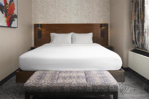 a bedroom with a large white bed and a bench at Hilton Garden Inn New York/Midtown Park Avenue in New York