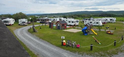 a park with a bunch of rvs and a playground at Le Pirate Motel et Camping in Cap-Chat