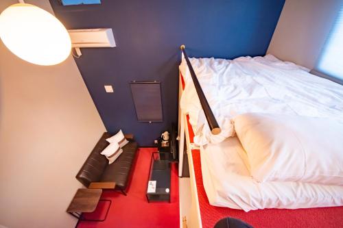 a small bedroom with a bed and a staircase at LOCO Minamiichi in Nara