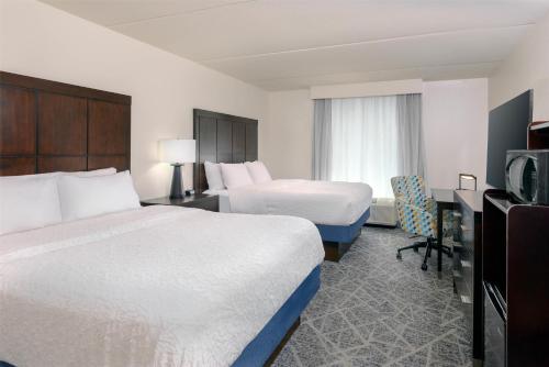 a hotel room with two beds and a television at Hampton Inn & Suites Pensacola/Gulf Breeze in Gulf Breeze