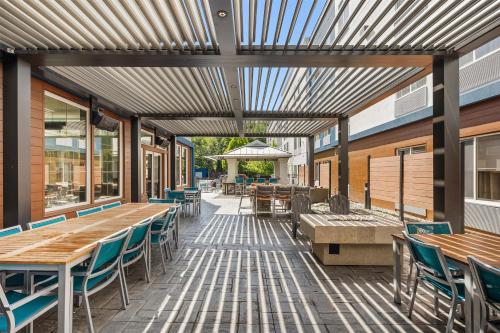 an outdoor patio with wooden tables and chairs at Hampton Inn & Suites Seattle North/Lynnwood in Lynnwood