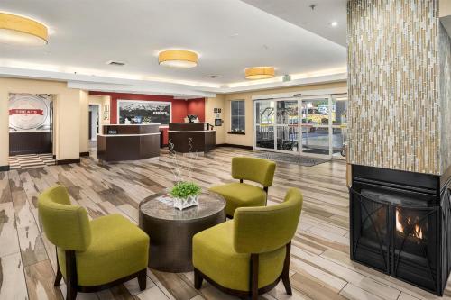 a lobby with a fireplace and green chairs at Hampton Inn & Suites Seattle North/Lynnwood in Lynnwood