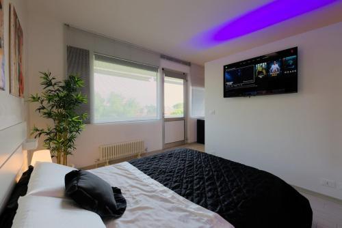 a bedroom with a bed with a tv on the wall at Bilocale Luxury fronte Ospedale in Udine