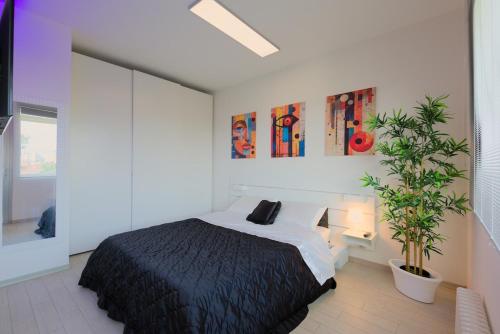 a bedroom with a bed and a potted plant at Bilocale Luxury fronte Ospedale in Udine