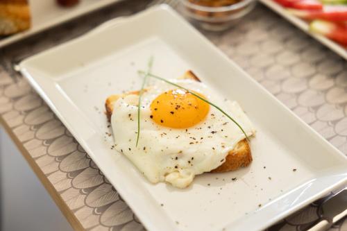 a fried egg on a plate on a table at Domus Terravecchia in Agrigento