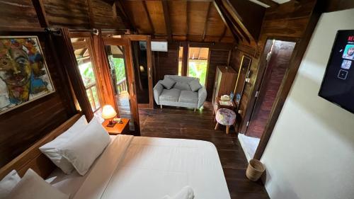 a bedroom with a bed and a chair in a room at Tahlia's Villa in Sorongjukung