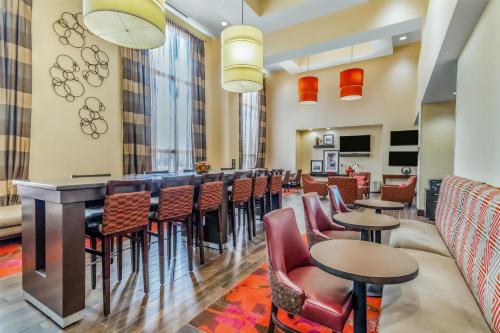 a bar in a restaurant with chairs and tables at Hampton Inn & Suites Detroit/Airport Romulus in Romulus