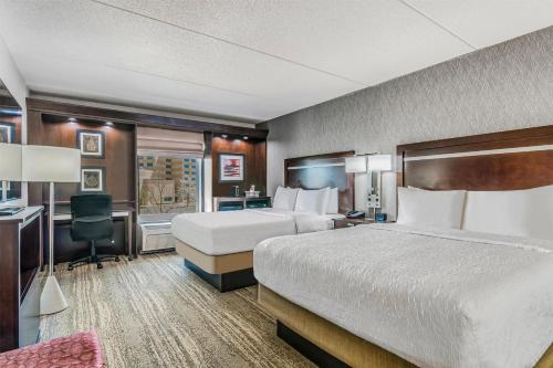 a hotel room with a bed and a desk at Hampton Inn & Suites Detroit/Airport Romulus in Romulus