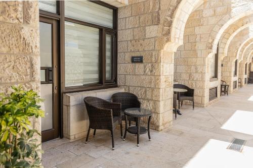 a patio with chairs and tables in a building at New Gate Hostel in Jerusalem