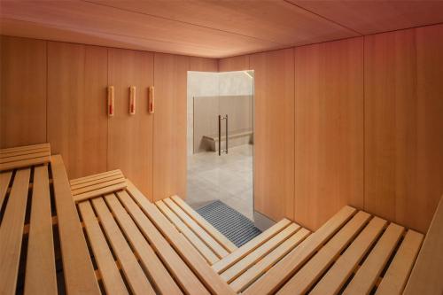 a sauna with a wooden bench in a room at Hilton Frankfurt Airport in Frankfurt