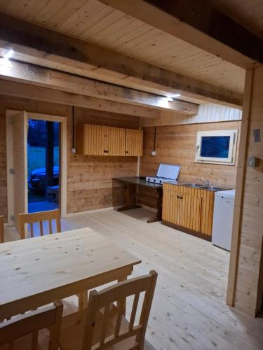 - une cuisine et un coin repas dans une cabine avec une table dans l'établissement Tourist Farm Pr' Maretč, à Bohinjska Bistrica