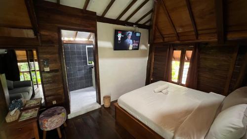a bedroom with a bed and a tv on the wall at Tahlia's Villa in Sorongjukung