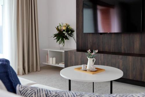 a living room with a table with flowers on it at Portopiccolo Apartments in Sistiana