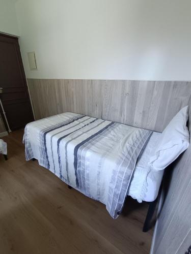 - une chambre avec un lit et une couette à rayures dans l'établissement AcG, à Villeneuve-Saint-Georges