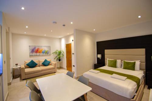 a bedroom with a bed and a table and a couch at Hyde Park Superior Apartments in London