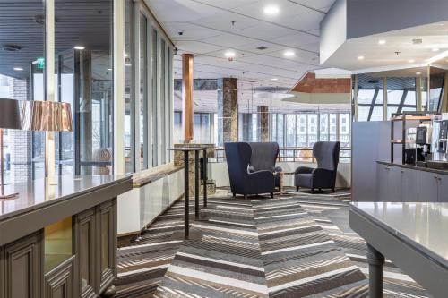 an office lobby with chairs and a bar at Hilton Helsinki Strand in Helsinki