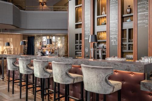 a bar in a restaurant with stools at Hilton Helsinki Strand in Helsinki