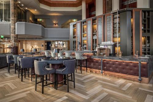 a bar with chairs and tables in a restaurant at Hilton Helsinki Strand in Helsinki