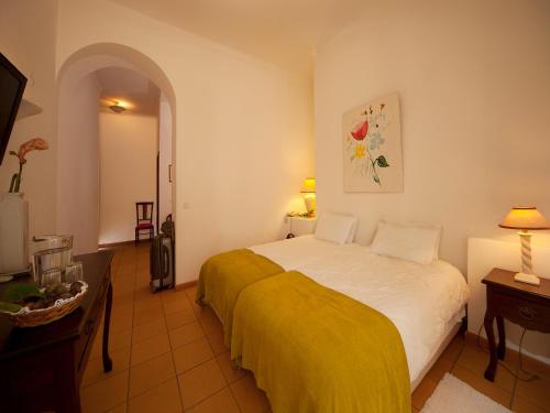 a bedroom with a bed with a yellow blanket at Betica Hotel Rural in Pias