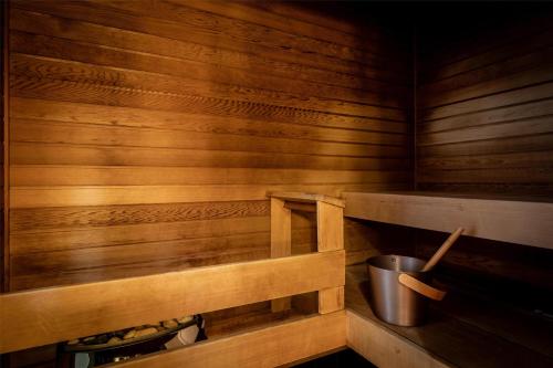 a sauna with wooden walls and a bucket in it at Hilton Helsinki Kalastajatorppa in Helsinki
