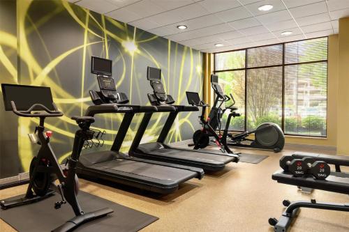 a gym with several tread machines in a room at Hilton Garden Inn Stony Brook in Stony Brook