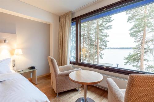 a hotel room with a bed and a large window at Hilton Helsinki Kalastajatorppa in Helsinki
