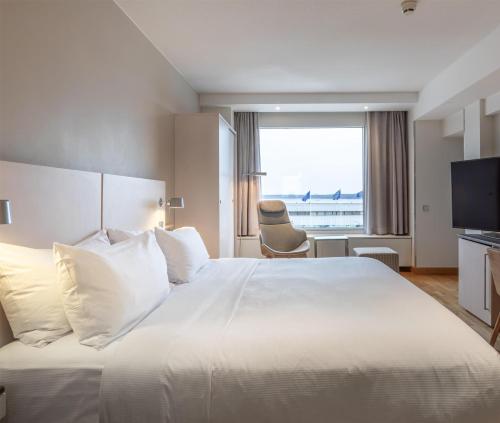 a hotel room with a large white bed and a window at Hilton Helsinki Kalastajatorppa in Helsinki