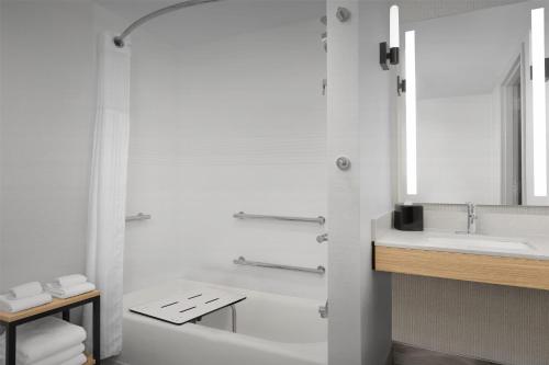 a white bathroom with a tub and a sink at Hilton Garden Inn Huntsville/Space Center in Huntsville