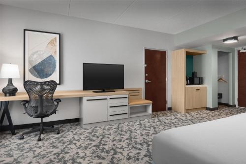a hotel room with a desk with a computer and a television at Hilton Garden Inn Huntsville/Space Center in Huntsville