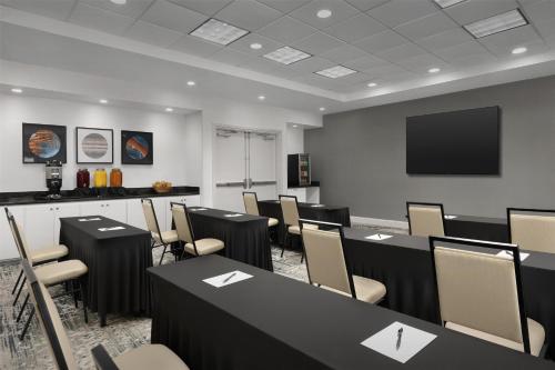 a conference room with tables and chairs and a flat screen tv at Hilton Garden Inn Huntsville/Space Center in Huntsville